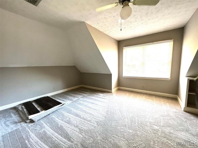 bonus room with lofted ceiling, ceiling fan, light carpet, and a textured ceiling