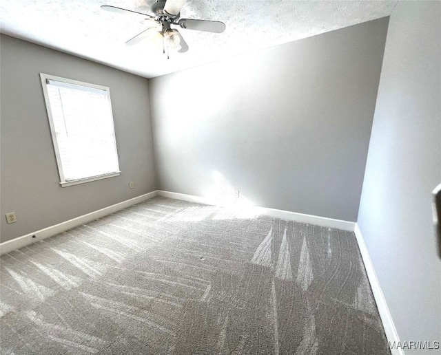 carpeted spare room with ceiling fan and a textured ceiling