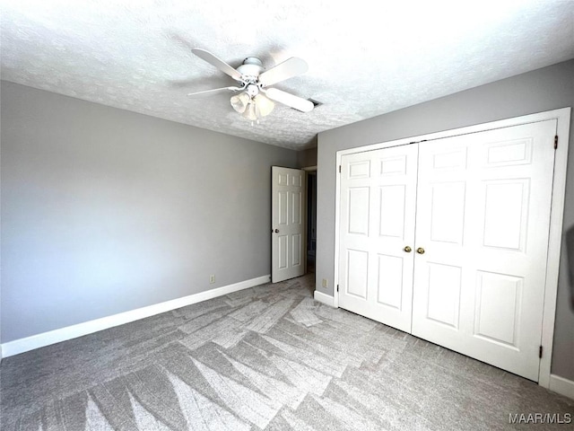 unfurnished bedroom with light carpet, a textured ceiling, a closet, and ceiling fan