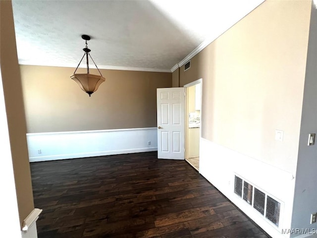 empty room with dark hardwood / wood-style flooring and ornamental molding