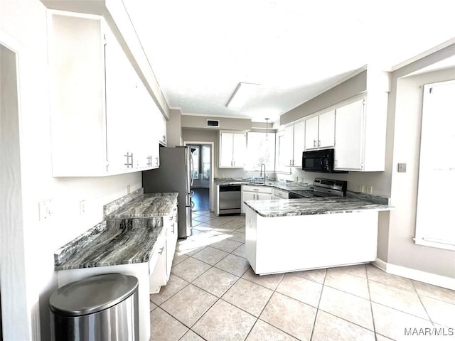 kitchen featuring white cabinets, sink, light tile patterned floors, appliances with stainless steel finishes, and kitchen peninsula