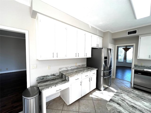 kitchen featuring light stone counters, ornamental molding, stainless steel appliances, light tile patterned floors, and white cabinets