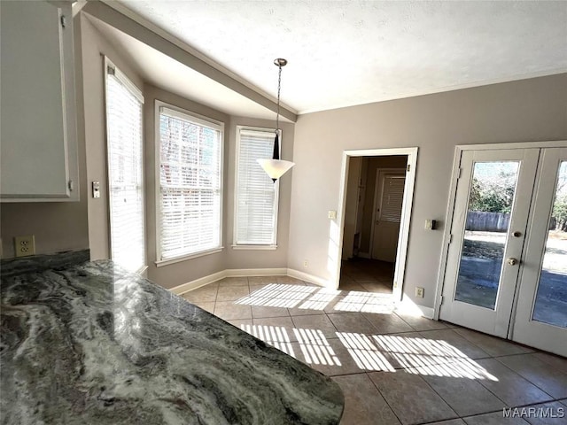 tiled dining area featuring a wealth of natural light, french doors, and lofted ceiling