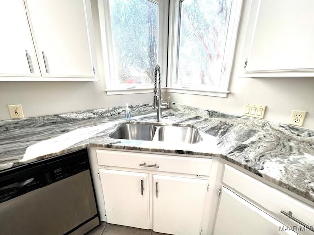 kitchen featuring light stone countertops, white cabinetry, sink, and stainless steel dishwasher