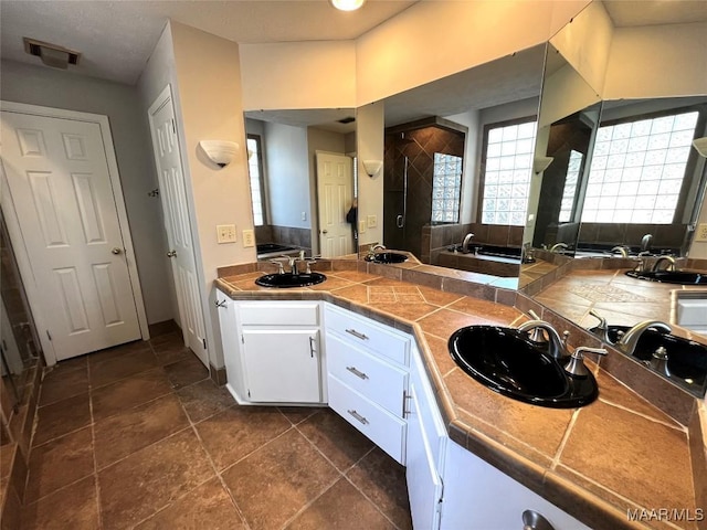 bathroom featuring vanity and independent shower and bath