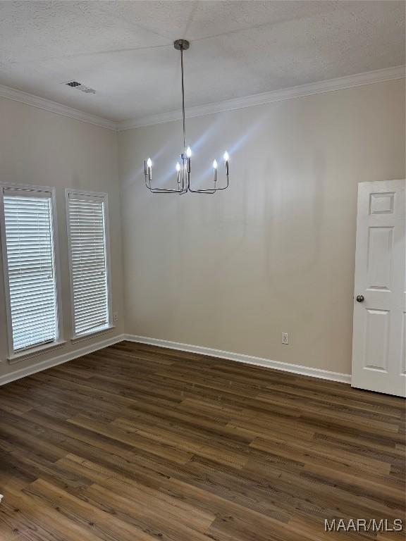 unfurnished dining area with a notable chandelier, crown molding, and dark wood-type flooring