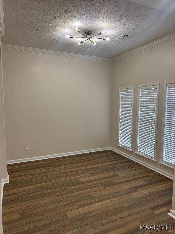 empty room with crown molding, dark hardwood / wood-style floors, and a textured ceiling