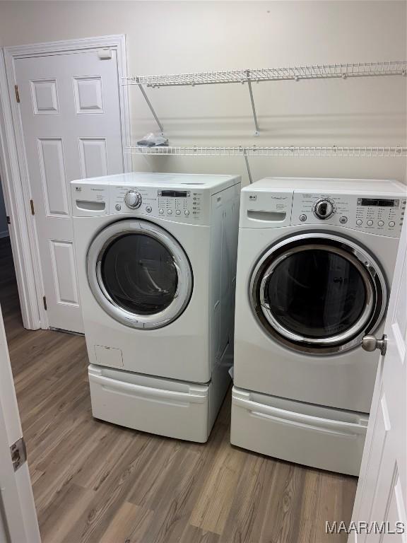 washroom featuring hardwood / wood-style floors and independent washer and dryer