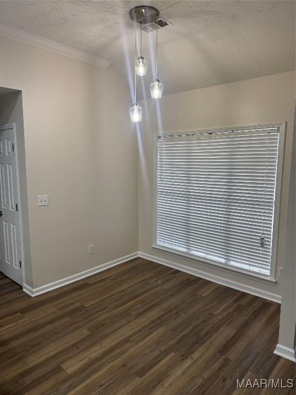 unfurnished dining area featuring a wealth of natural light, crown molding, dark hardwood / wood-style floors, and a textured ceiling