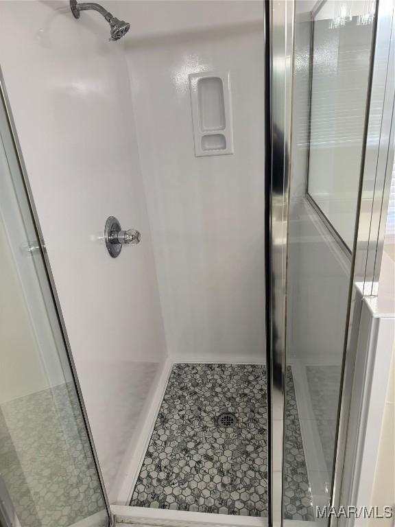 bathroom featuring tile patterned flooring and a shower with shower door