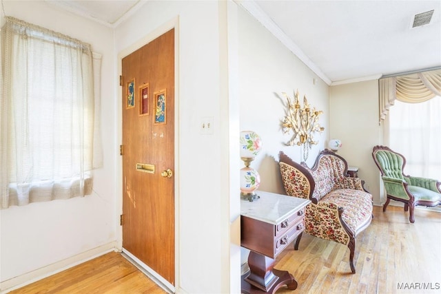 sitting room with crown molding, light hardwood / wood-style flooring, and plenty of natural light