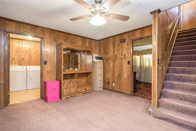 carpeted living room with a textured ceiling, ceiling fan, crown molding, and washing machine and clothes dryer