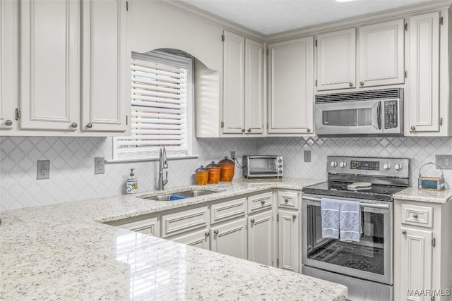 kitchen with white cabinets, backsplash, stainless steel appliances, and sink