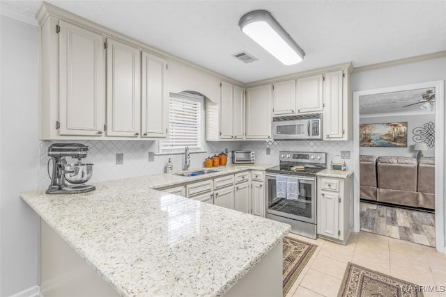 kitchen with kitchen peninsula, appliances with stainless steel finishes, and sink