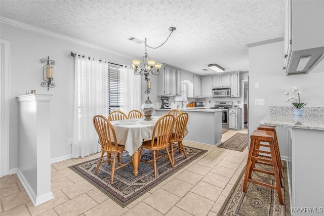 tiled dining space featuring an inviting chandelier, a textured ceiling, and ornamental molding