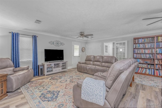 living room featuring a textured ceiling, light hardwood / wood-style floors, ceiling fan, and ornamental molding