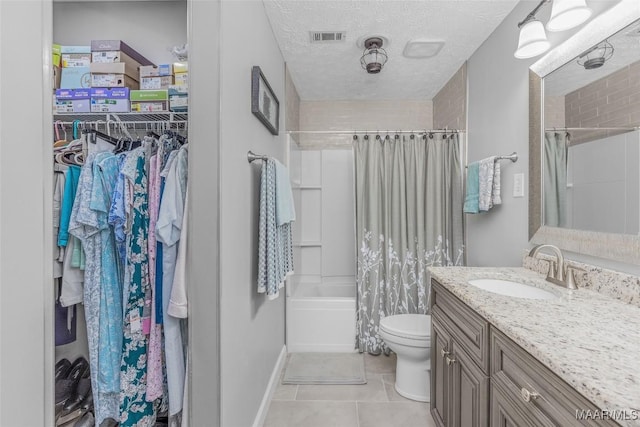 full bathroom featuring tile patterned floors, vanity, toilet, and a textured ceiling