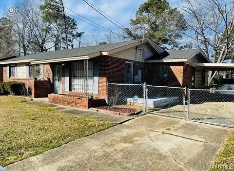 single story home featuring a front lawn and a carport