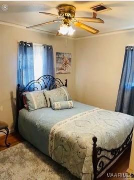 bedroom with ceiling fan and crown molding