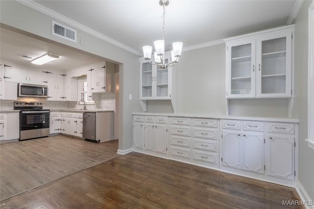 kitchen with white cabinetry, dark wood-type flooring, tasteful backsplash, pendant lighting, and appliances with stainless steel finishes