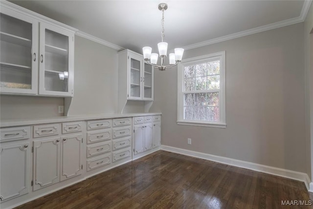 unfurnished dining area with a notable chandelier, dark hardwood / wood-style floors, and crown molding