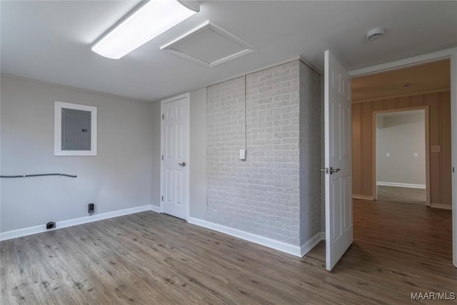 clothes washing area featuring hardwood / wood-style floors and electric panel