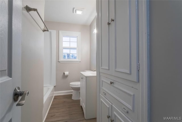 full bathroom with hardwood / wood-style flooring, vanity,  shower combination, and toilet