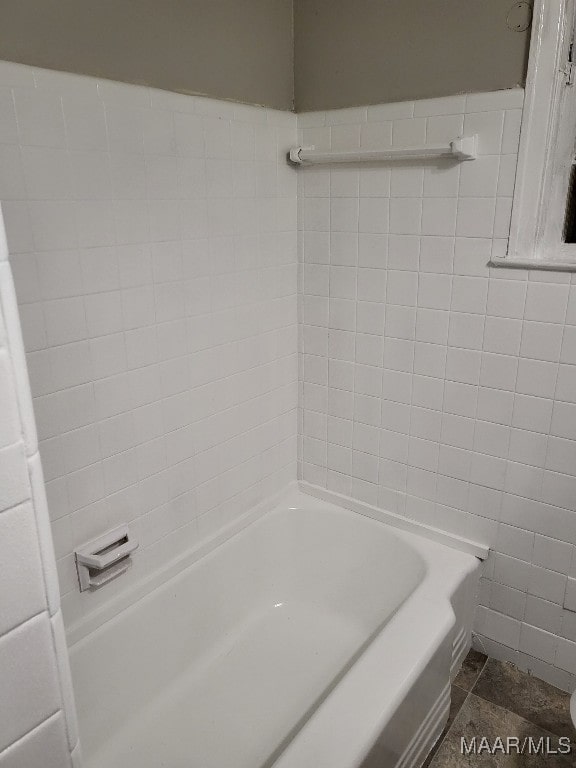 bathroom featuring tile patterned floors, tile walls, and a tub