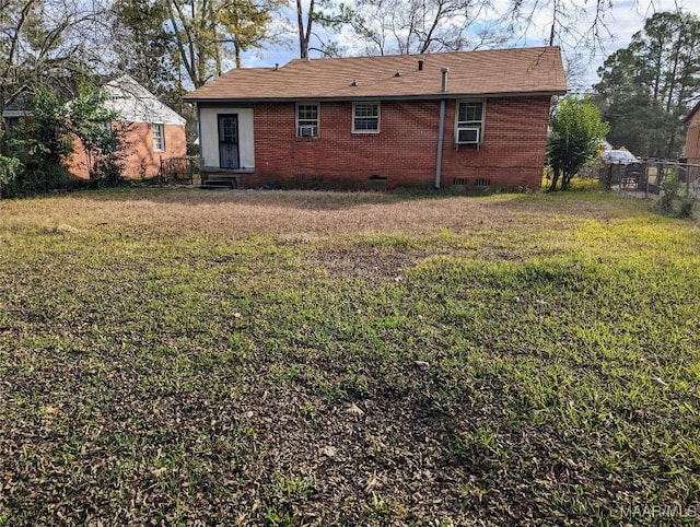 back of house with cooling unit and a lawn