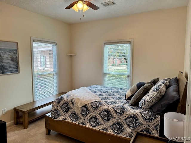 bedroom featuring light carpet, multiple windows, and ceiling fan