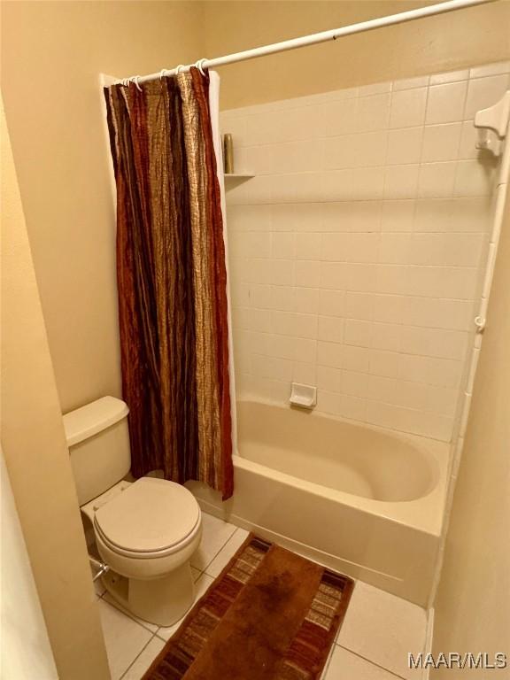 bathroom with tile patterned flooring, toilet, and shower / bath combo with shower curtain