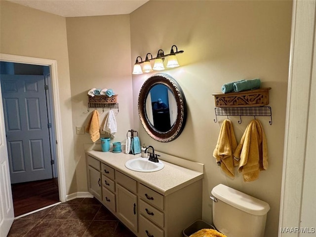 bathroom with tile patterned flooring, vanity, and toilet