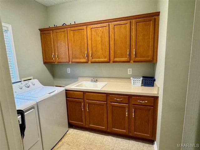 laundry room with cabinets, separate washer and dryer, and sink