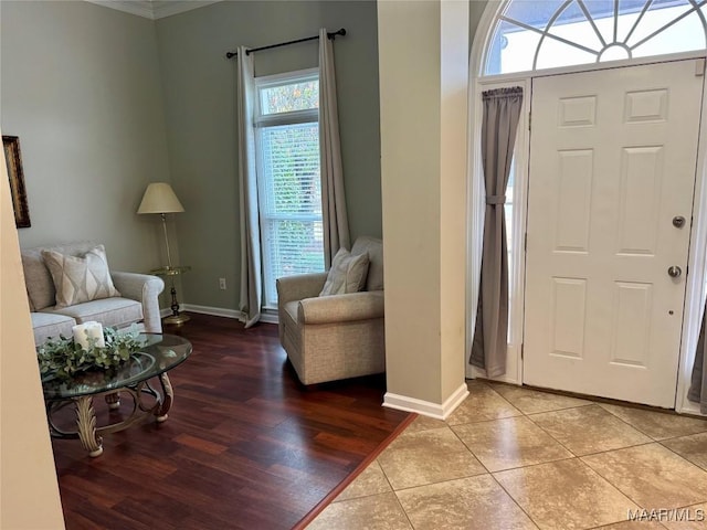 entrance foyer featuring crown molding, hardwood / wood-style floors, and a healthy amount of sunlight