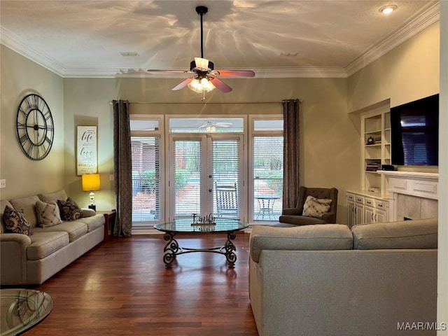 living room featuring french doors, built in shelves, ceiling fan, ornamental molding, and dark hardwood / wood-style flooring