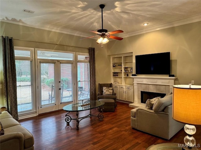 living room with a fireplace, a wealth of natural light, built in features, and ceiling fan