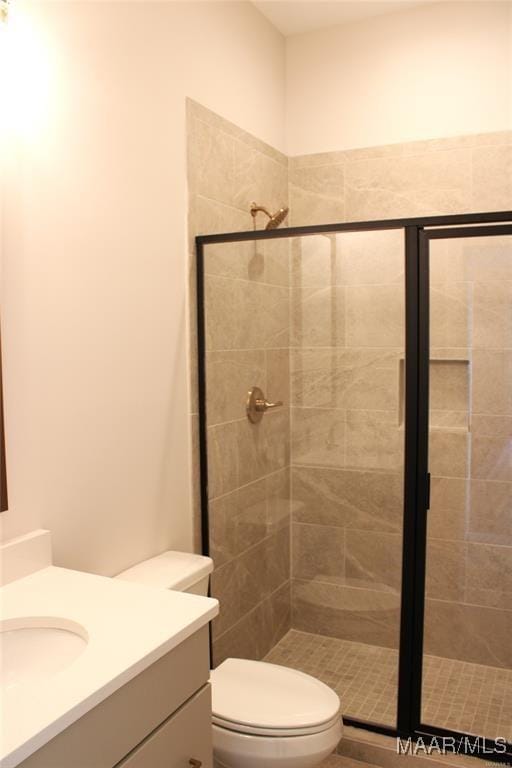 bathroom featuring walk in shower, vanity, and toilet