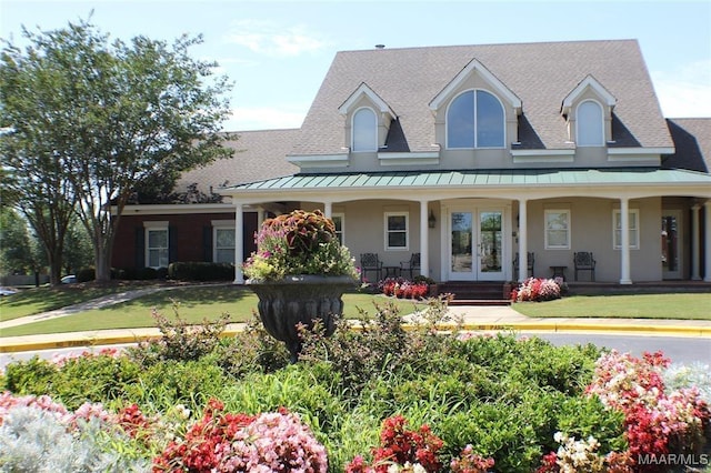 view of front of home with french doors, a porch, and a front lawn