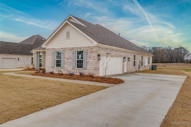 view of front of property featuring driveway, roof with shingles, an attached garage, a front lawn, and brick siding