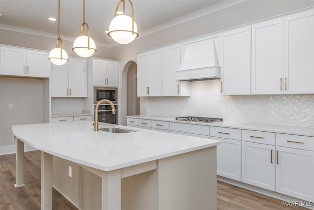 8325 Young Xing, Montgomery, AL 36116 - kitchen with custom range hood, black microwave, crown molding, light wood-style floors, and tasteful backsplash