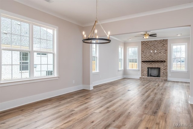 8325 Young Xing, Montgomery, AL 36116 - unfurnished living room featuring healthy amount of natural light, ornamental molding, wood finished floors, a chandelier, and a brick fireplace