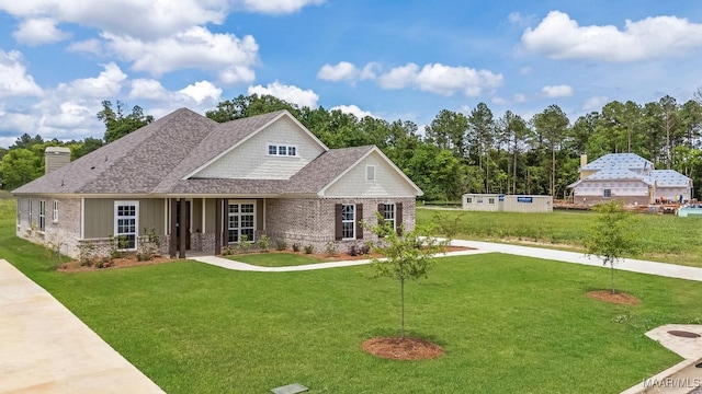 8325 Young Xing, Montgomery, AL 36116 - view of front facade with a front yard, a shingled roof, and brick siding