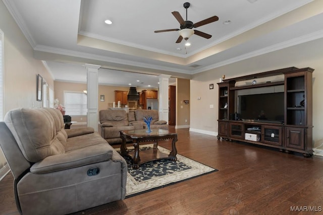 living room featuring a raised ceiling, ceiling fan, and ornamental molding