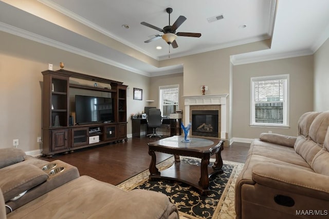 living room with ceiling fan, a fireplace, crown molding, and dark hardwood / wood-style floors