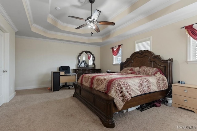 bedroom with a tray ceiling, crown molding, ceiling fan, and light colored carpet