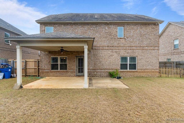 rear view of house with ceiling fan, a yard, and a patio