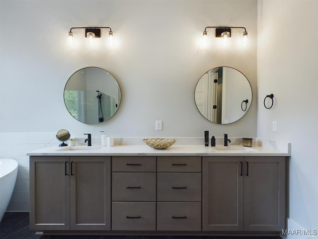 bathroom featuring tile patterned floors, vanity, and a bath