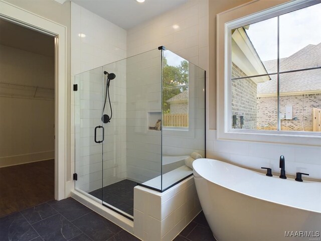 bathroom featuring separate shower and tub, tile patterned flooring, and tile walls