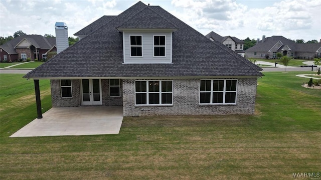 rear view of property with a patio and a lawn