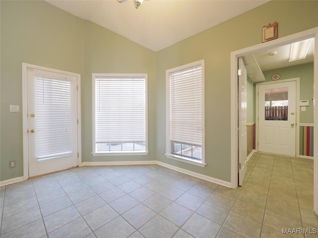 unfurnished room featuring light tile patterned floors, an inviting chandelier, and vaulted ceiling